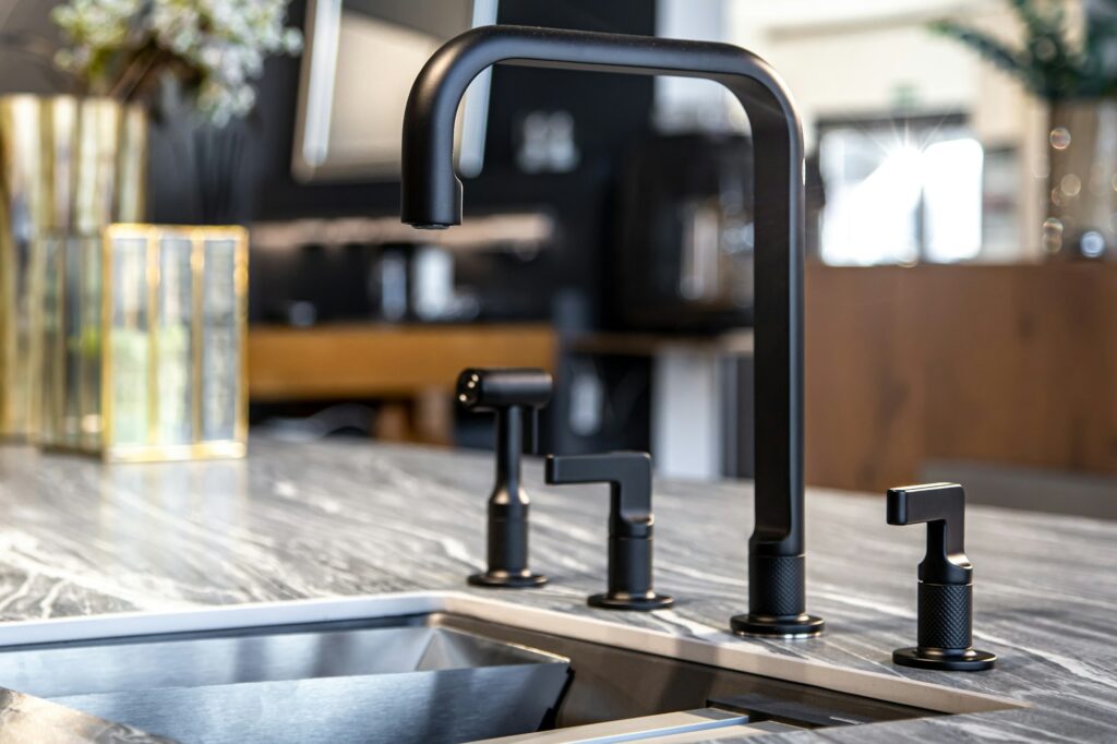 Black faucet with a steel sink in a stylish modern kitchen.