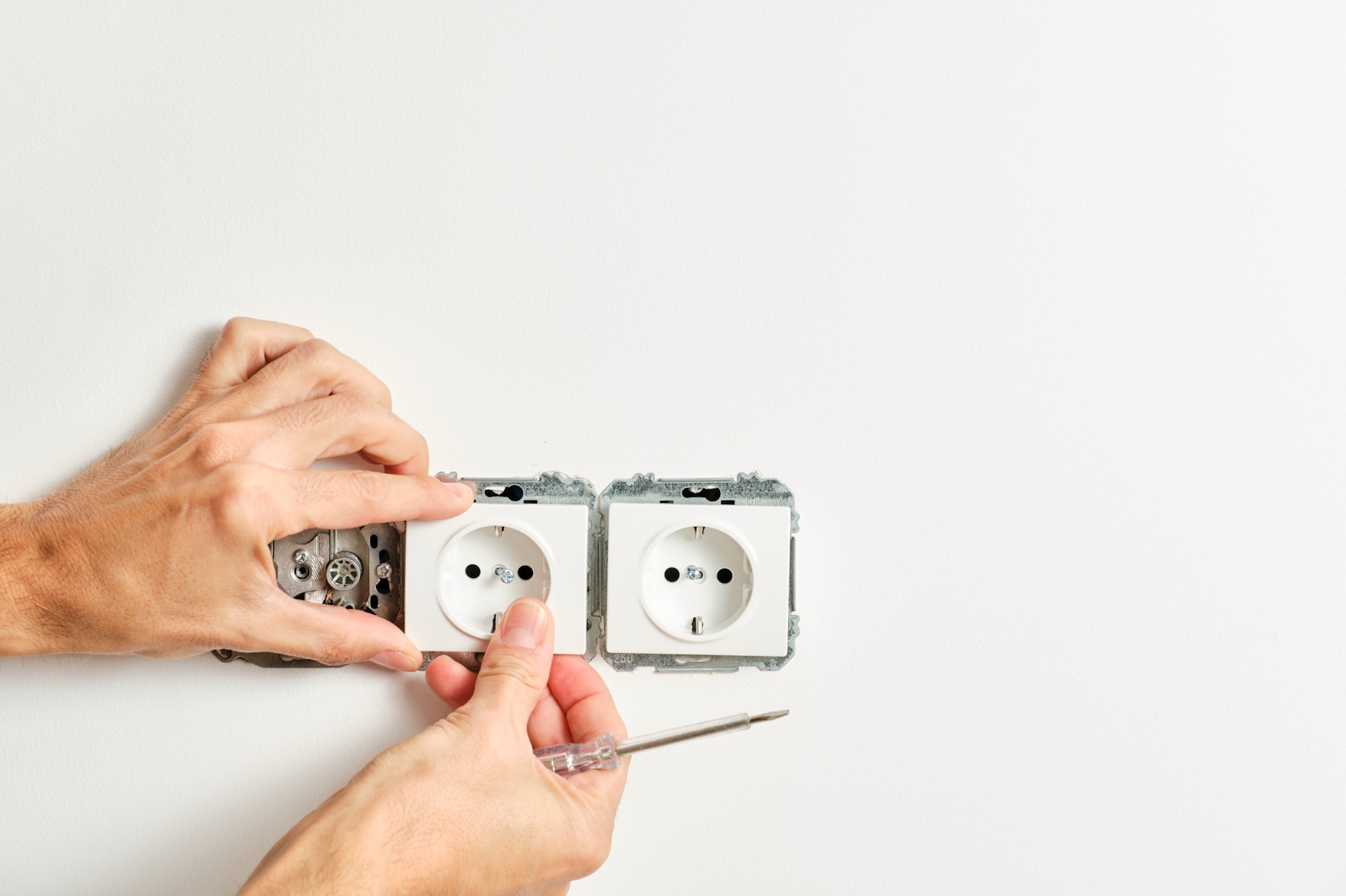 man's hands fixing a plug